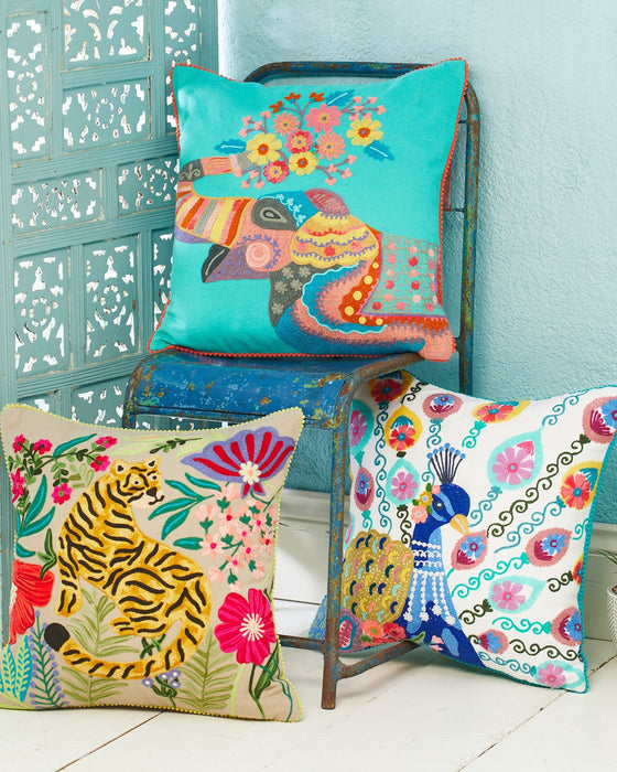 Colorful animal-themed pillows on a chair against a light blue wall.