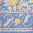 Border section of the Aasmani hand-block-printed cotton tablecloth with pink and yellow botanicals on a dusty blue background