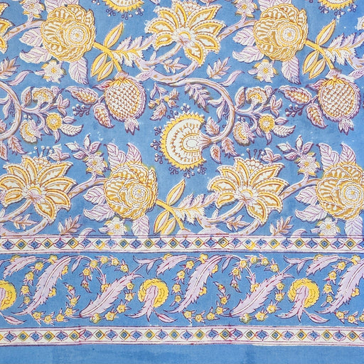 Aasmani hand-block-printed cotton tablecloth with pink and yellow botanicals on a dusty blue background