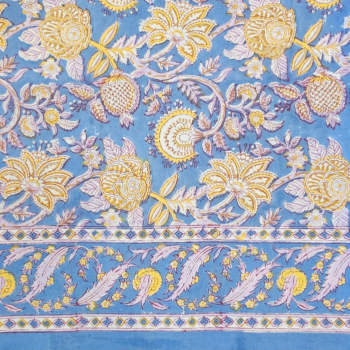 Aasmani hand-block-printed cotton tablecloth with pink and yellow botanicals on a dusty blue background