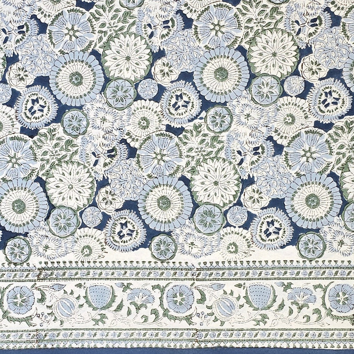 A deep blue, white and green floral tablecloth with the design name Arctic Mandala