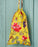 Yellow drawstring bag with floral pattern hanging on a light blue wooden panel.