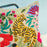 Decorative pillow with a tiger and floral design on a blue background