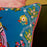 Decorative pillow with floral and butterfly design on a dark background