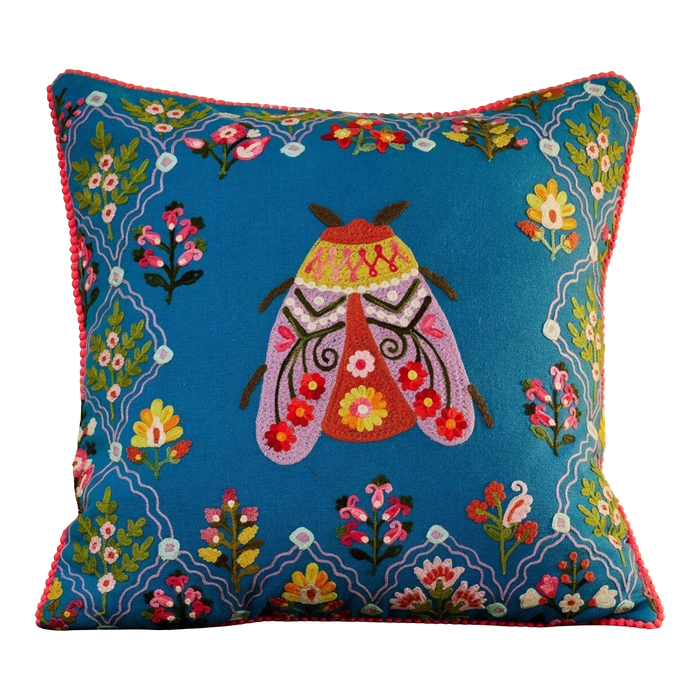 Decorative pillow with embroidered butterfly design on a couch