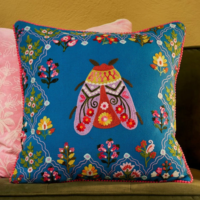 Blue cotton canvas cushion cover with embroidered bug and floral border.  45x45cm.