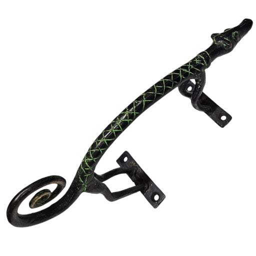 A brass handle with a green patina and a curly tail design on a white background