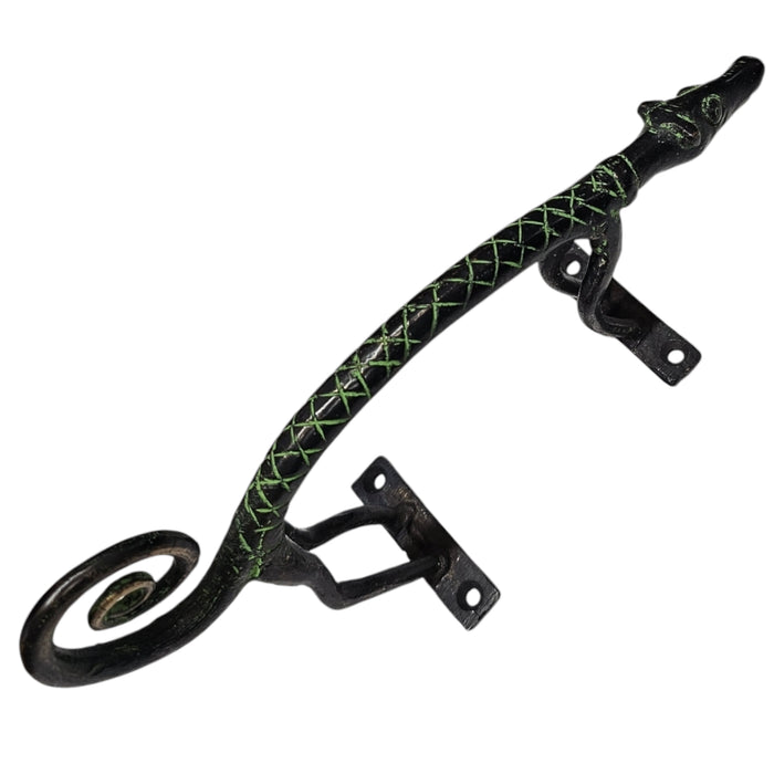 A brass handle with a green patina and a curly tail design on a white background
