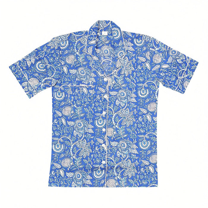A short-sleeve button-up pyjama top with a vibrant blue-and-white floral block-print pattern, laid flat against a white background.