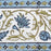 Close up detail of the border of a white cotton tablecloth hand-block printed with soft blue flowers and sage green leaves.