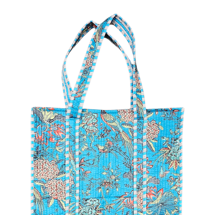Exotic birds and florals printed design on a sky blue quilted cotton tote bag on a plain white background