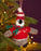 Felt baby penguin Christmas decoration wearing a red sweater and hat, hanging on a Christmas tree.