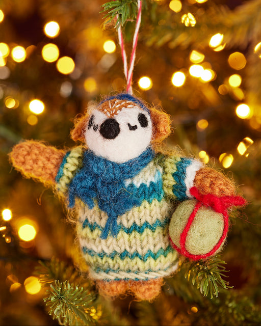 Felt Cosy Fox Christmas Decoration hanging on a Christmas tree with lights in the background.