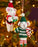 Two knitted mouse ornaments on a Christmas tree with lights in the background