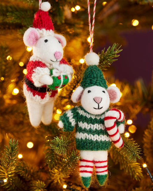 Two knitted mouse ornaments on a Christmas tree with lights in the background