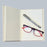 open handmade paper notebook with pen and a pair of glasses on the page 