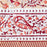 A close-up of a printed cotton tablecloth border featuring red and orange paisley and floral motifs on a warm peach background.