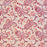 A close-up of a printed cotton tablecloth featuring red and orange paisley and floral motifs on a warm peach background.