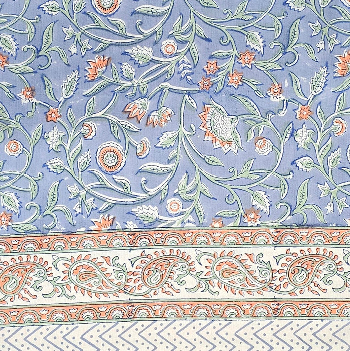 Blue block printed cotton tablecloth with a green and orange floral design.