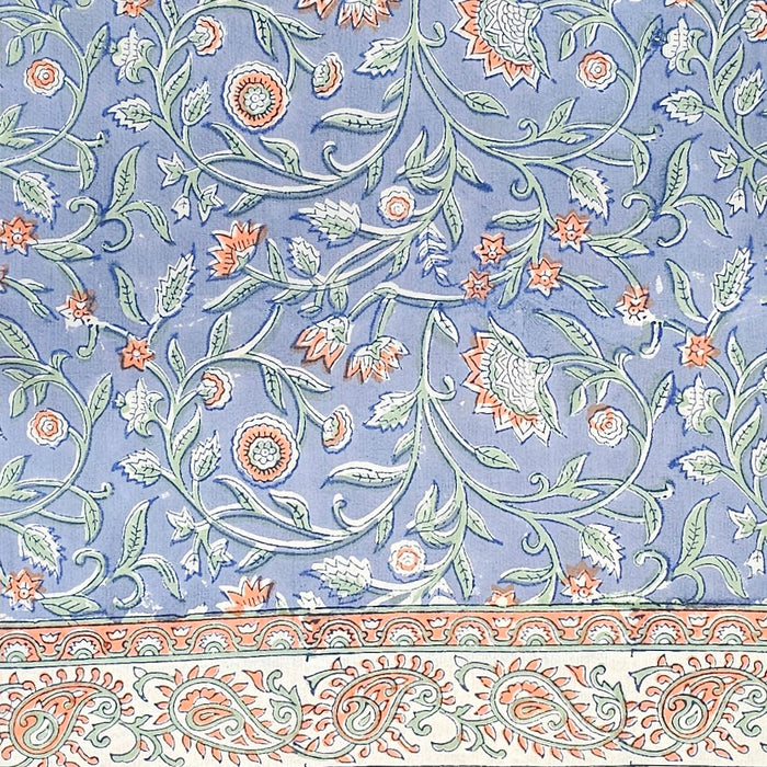 Decorative floral pattern with orange and green elements on a blue background