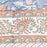 Close up picture of the border of a blue block printed cotton tablecloth with a green and orange floral design.