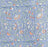 Close up picture of a blue block printed cotton tablecloth with a green and orange floral design.