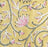 close up of a block print marigold design floral tablecloth in pink and green on a yellow background.