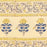 Detailed picture showing the border of a hand block printed tablecloth with a blue and grey foral design on a mustard yellow background.