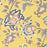 A close up picture of a hand block printed tablecloth with a blue and grey foral design on a mustard yellow background.