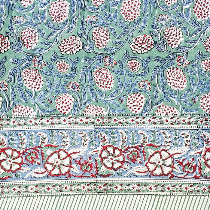 Floral patterned fabric with red and white flowers on a green background