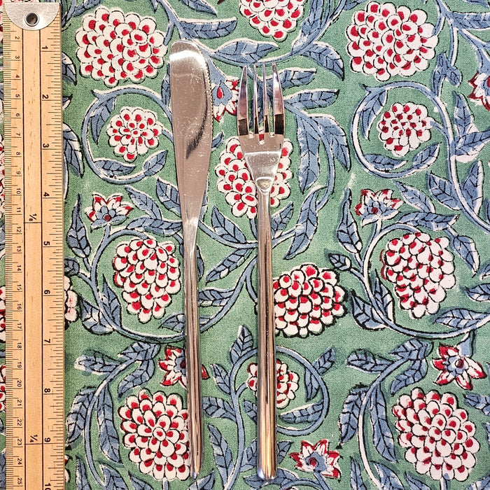 Block printed pomegranite design cotton tablecloth shown with a knife and fork with a ruler to show the scale of the pattern.