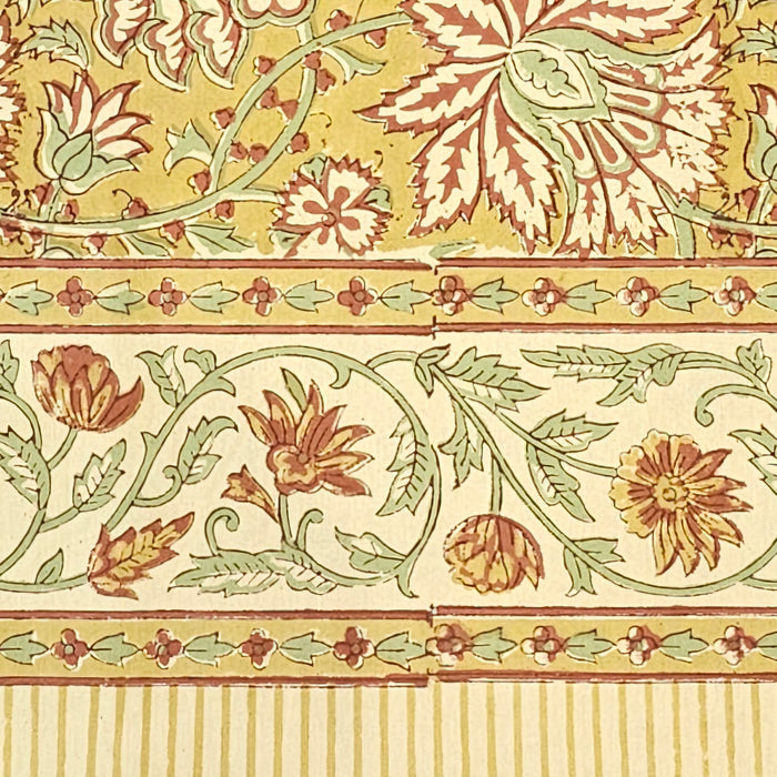 Golden turmeric hand-block printed cotton tablecloth with terracotta floral vines and sage green accents showing the border design.