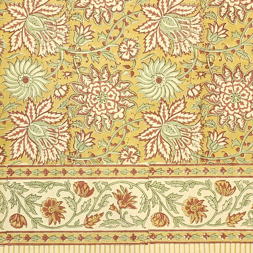 Golden turmeric hand-block printed cotton tablecloth with terracotta floral vines and sage green accents.