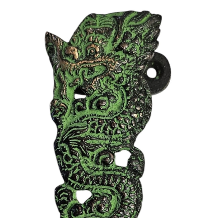 Close up image of the head of a Long Dragon Design Green Patina Brass Handle against a white background