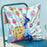 Colorful pillow with peacock design on a blue chair against a light blue wall.