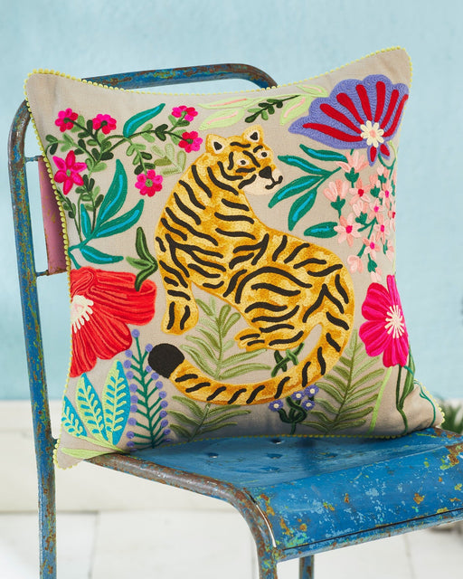 Decorative pillow with a tiger design on a chair against a light blue background