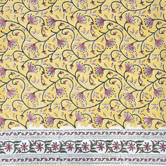 Decorative fabric pattern with pink flowers and green leaves on a yellow background