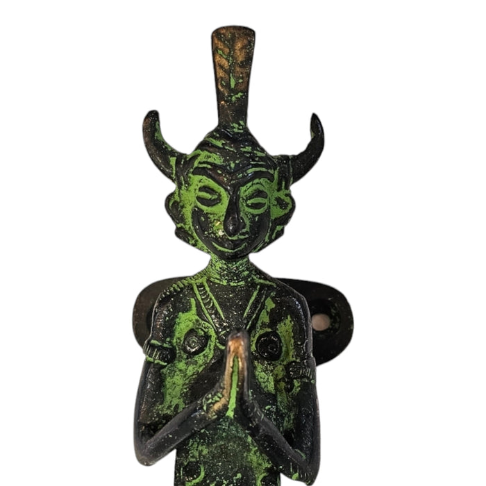 Close up image of a Namaste Figure Green Patina Brass Handle on a white background