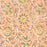 A close-up of a peach-colored fabric tablecloth with an all-over floral block print in green, yellow, and brown
