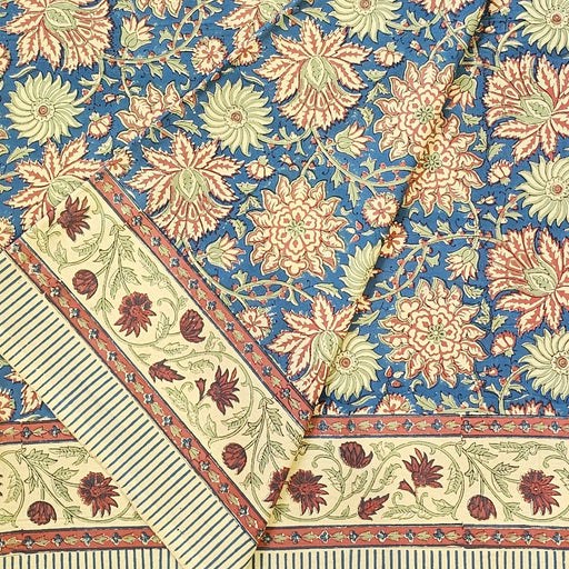 Dusky indigo slate hand-block printed cotton tablecloth with Terracotta-rust, warm peach-cream, and soft sage-celadon botanicals.  The tablecloth is folded.