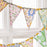 Colorful floral fabric bunting hanging against a white window frame.