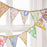 Floral patterned bunting hanging against a white window frame.