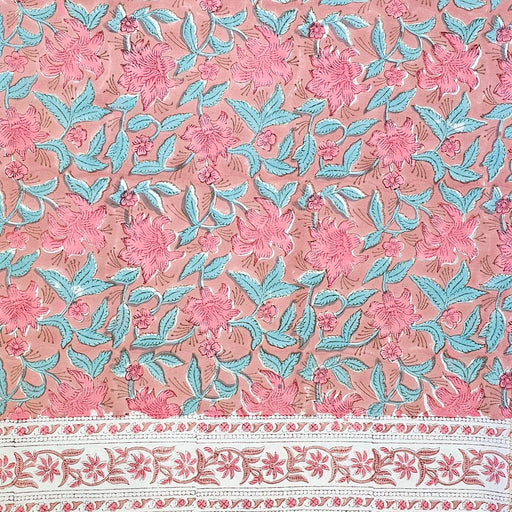 Floral-patterned tablecloth with pink flowers and blue leaves on a pink background