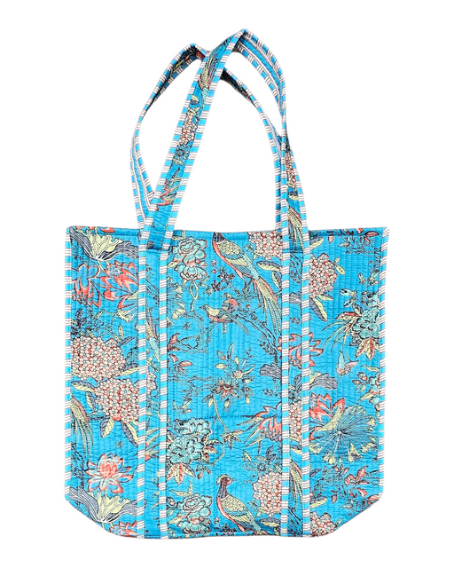 Floral and bird-patterned tote bag on a blue background