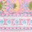 A close-up of a pink patterned tablecloth featuring hand-painted style floral motifs in yellow, green, and light blue, with decorative horizontal borders.