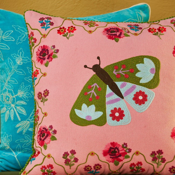 Decorative pillow with a butterfly design on a pink background
