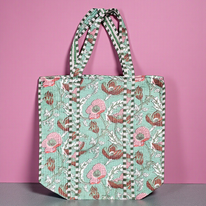 Sage Meadow Quilted Cotton Tote Bag on a grey shelf and set against a pink backdrop