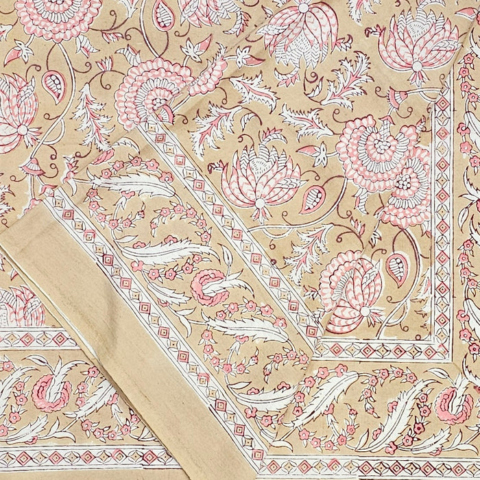 Decorative block printed tablecloth with pink and white floral pattern on a beige background