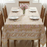 Dining table set with a block printed tablecloth, plates, and chairs in a bright room.