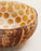 Coconut shell bowl with honeycomb pattern on a light background